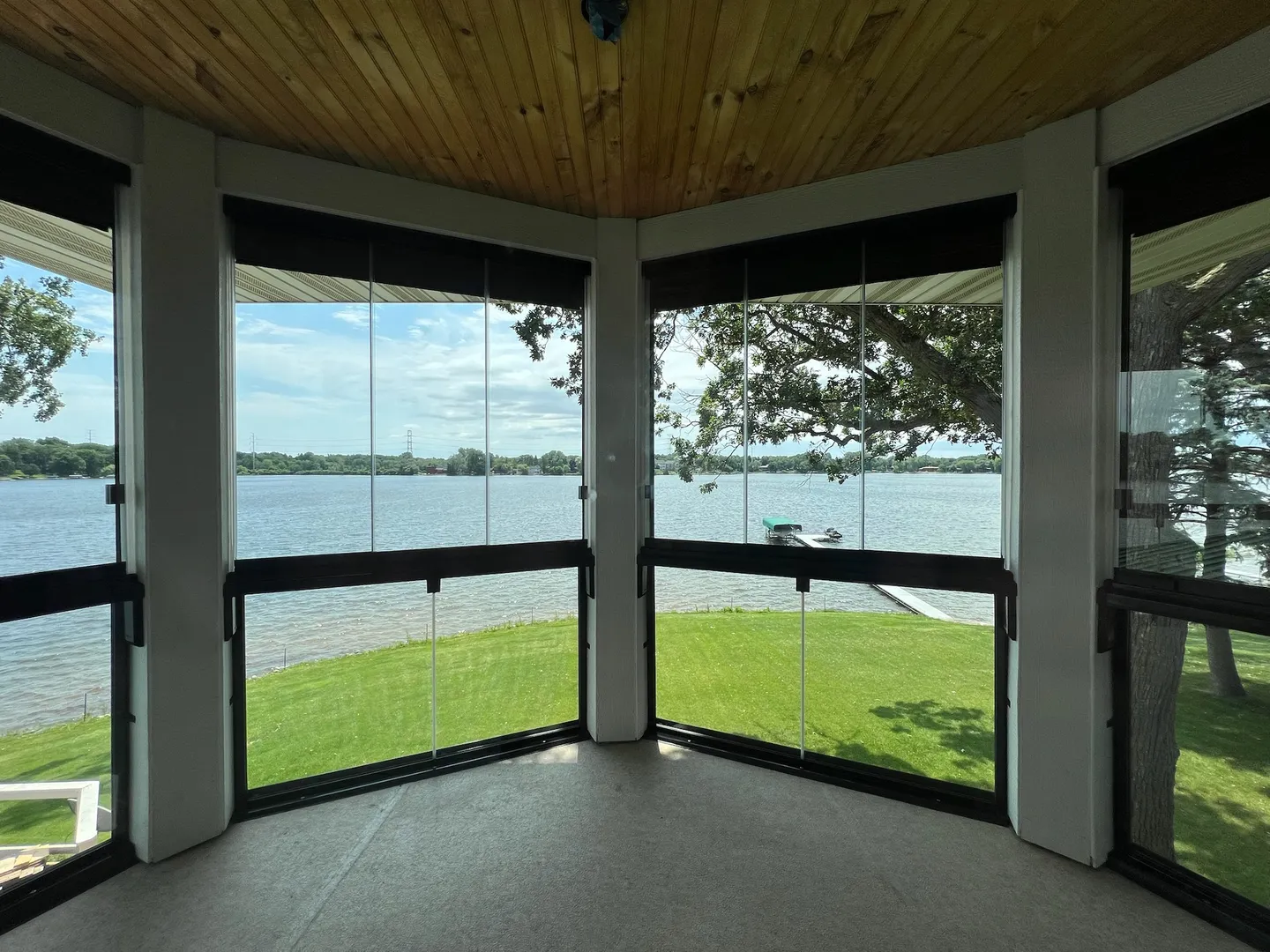 Wraparound porch with glass panels and open lake views