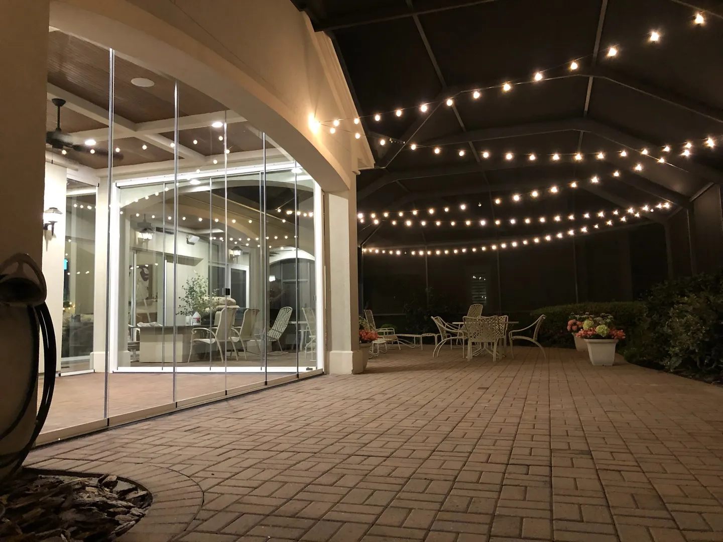 Glazed patio under string lights at dusk