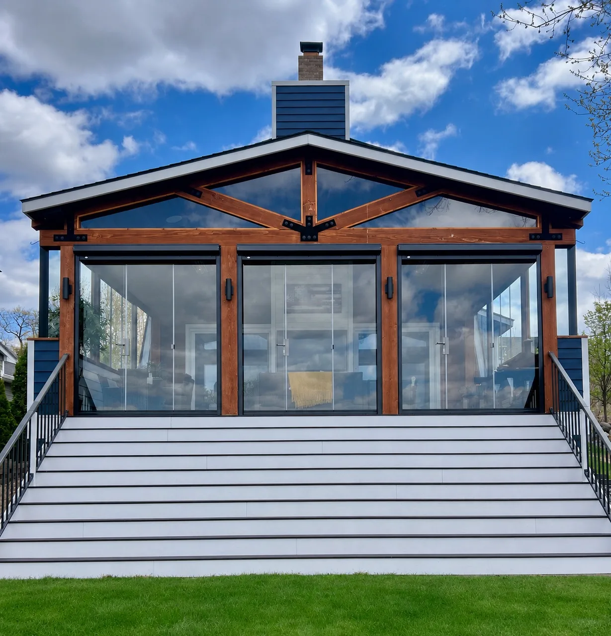 White gable pavilion enclosed in frameless glass at the top of a wide stair